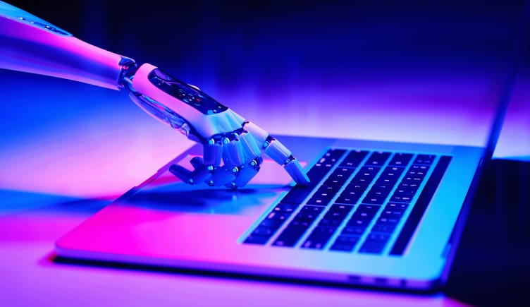 A robot are pressing the space bar on a laptop computer as a part of their robotic process automation.